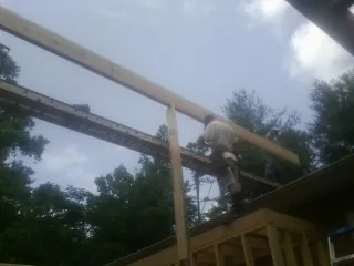 Carpenter setting a ridge beam over a new addition frame — Ice Dam Removal by Roofing Brothers in Hurlock