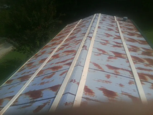 Rusted metal roof panels with new wood purlins before replacement — Storm Damage Roof Repair in Hurlock by Roofing Brothers